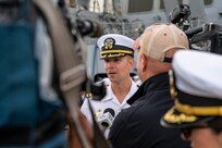 Cmdr. Adam Miller, commanding officer of the Arleigh Burke-class guided-missile destroyer USS Truxtun (DDG 103), speaks with local media upon returning to Naval Station Norfolk following a nine-month deployment with Carrier Strike Group (CSG) 10.