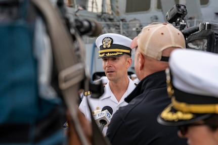 Cmdr. Adam Miller, commanding officer of the Arleigh Burke-class guided-missile destroyer USS Truxtun (DDG 103), speaks with local media upon returning to Naval Station Norfolk following a nine-month deployment with Carrier Strike Group (CSG) 10.
