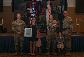 U.S. Army Maj. Gen. John V. Meyer III, commanding general of the 1st Infantry Division and Command Sgt. Maj. Christopher Mullinax, command sergeant major of the 1st Inf. Div. present Ashlee Vaughan, a graphic designer for the 3-1 Assault Helicopter Battalion, a Volunteer of the Quarter award during a Volunteer of the Quarter ceremony, May 12, 2023, at Victory Hall Division Headquarters, Fort Riley, K.S. This ceremony was held to honor Soldiers and volunteers that have made a significant impact on Fort Riley and its surrounding community. (U.S. Army photo by Spc. Ellison Schuman)