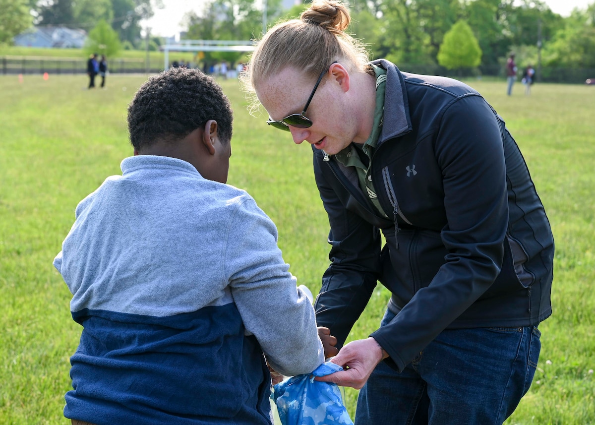 John Lyman, AFLCMC/WAG financial specialist, lets a child pick out a ping pong ball at the spoon race station during a field day event at Edison Elementary School in Dayton, Ohio, May 18,2023. The volunteers partnered with Edison Elementary School in Dayton, Ohio, to help them execute the event for the students. (U.S. Air Force photo by Staff Sgt. Mikaley Kline)
