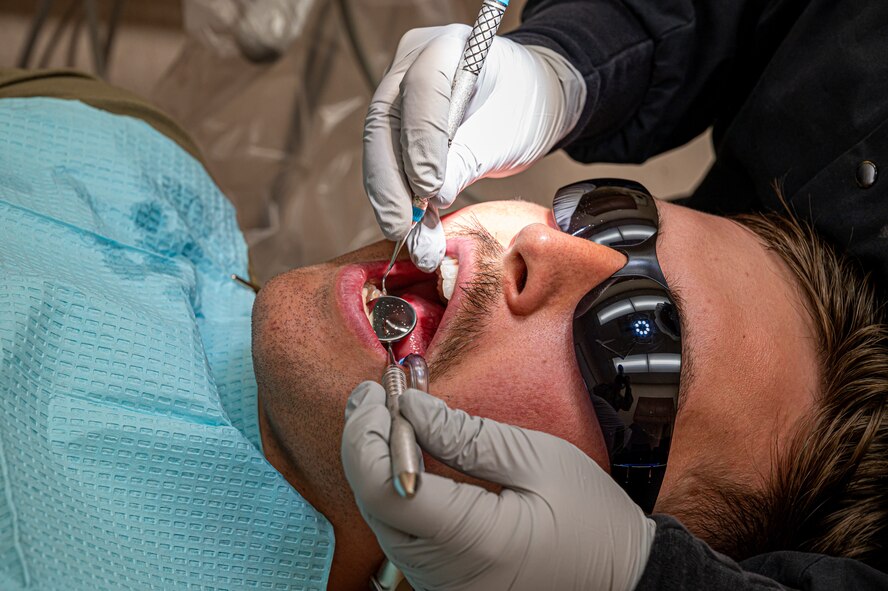 U.S. Air Force Senior Airman Thalia Morales-Diaz, 5th Medical Group dental technician, checks the gum health of a patient's mouth during a routine dental check-up at Minot Air Force base, North Dakota, April 27, 2023. Dental technicians ensure that patients remain healthy and comfortable at all times. (U.S. Air Force photo by Airman 1st Class Nottingham)