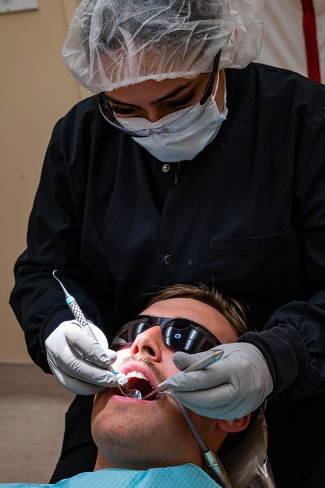 U.S. Air Force Senior Airman Thalia Morales-Diaz, 5th Medical Group dental technician, examines a patient's mouth during a routine dental check-up at Minot Air Force base, North Dakota, April 27, 2023. Air Force Dental technicians help provide patient care in every procedure. (U.S. Air Force photo by Airman 1st Class Nottingham)