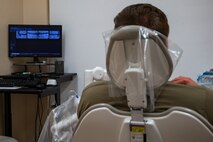 A patient at the 5th Bomb Wing Medical Group facility looks at his x-rays during a routine dental check-up at Minot Air Force Base, North Dakota, April 27, 2023. An X-ray allows dental staff to identify problems a patient may have with their gums and teeth. (U.S. Air Force photo by Airman 1st Class Nottingham)