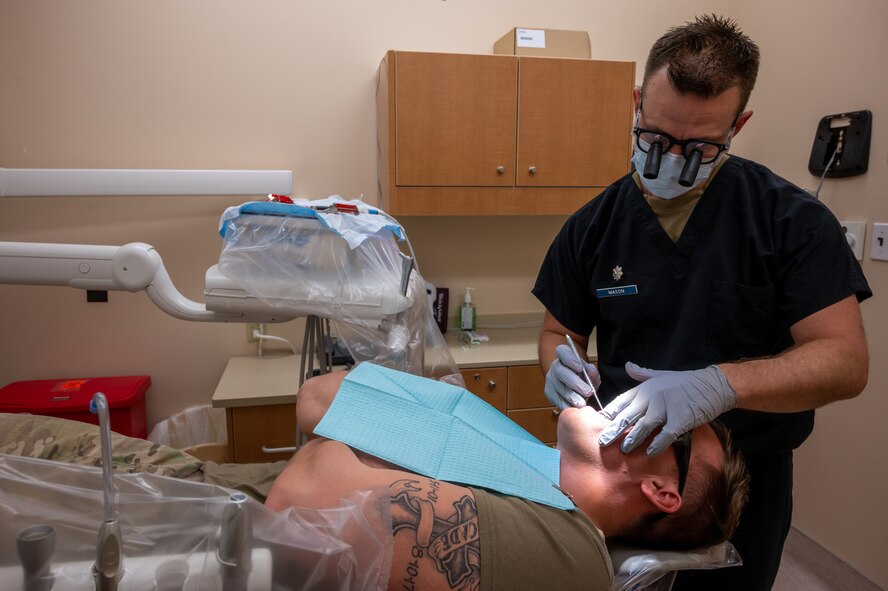 U.S. Air Force Lt. Col. Jared Mason, 5th Medical Group dentist, examines a patient's mouth during a routine dental check-up at Minot Air Force Base, North Dakota, April 27, 2023. The Air Force Dental Service’s mission is to provide innovative, expeditionary Airmen and Guardians to support global operations and ensure a dentally fit force through trusted care. (U.S. Air Force photo by Airman 1st Class Nottingham)