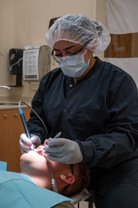 U.S. Air Force Senior Airman Thalia Morales-Diaz, 5th Medical Group dental technician, checks the gum health of a patient's mouth during a routine dental check-up at Minot Air Force Base, North Dakota, April 27, 2023. Dental technicians are responsible for aiding in every part of the practice from simple exams and taking x-rays to assisting in oral surgery. (U.S. Air Force photo by Airman 1st Class Nottingham)