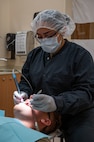 U.S. Air Force Senior Airman Thalia Morales-Diaz, 5th Medical Group dental technician, checks the gum health of a patient's mouth during a routine dental check-up at Minot Air Force Base, North Dakota, April 27, 2023. Dental technicians are responsible for aiding in every part of the practice from simple exams and taking x-rays to assisting in oral surgery. (U.S. Air Force photo by Airman 1st Class Nottingham)