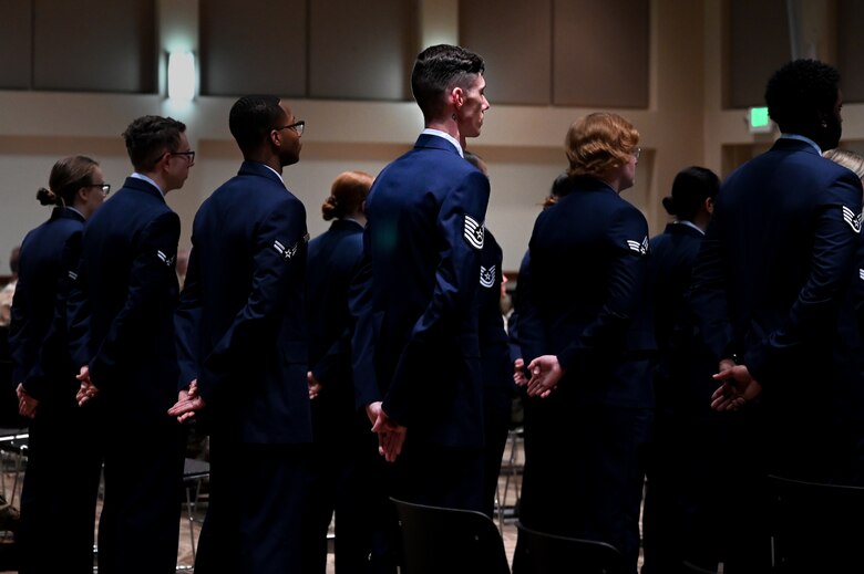 Service membrs in dress blues stand in formation