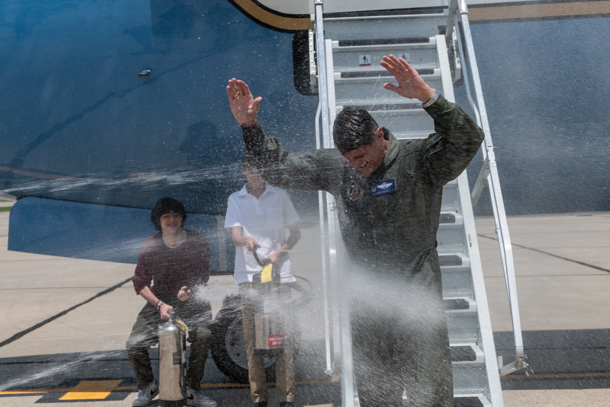 Col. Glenn Collins, 932nd Airlift Wing commander, gets sprayed with water by his family and 932nd AW personnel after his flight at Scott Air Force Base, Ill., May 24, 2023.