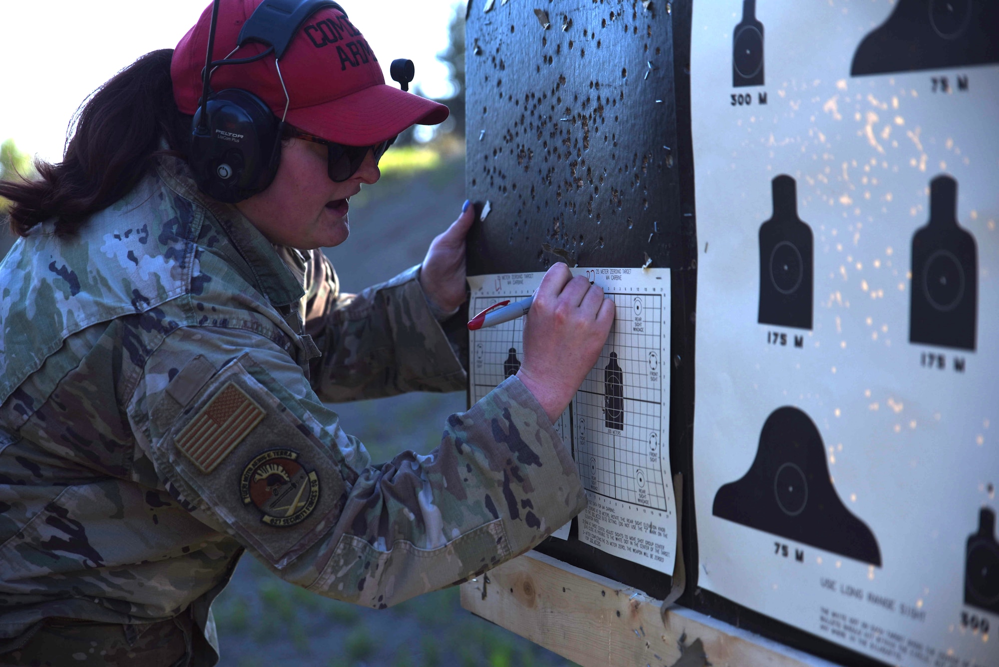 U.S. Air Force Senior Airman Lindsay Francher, combat arms instructor with the 627th Security Forces Squadron, scores a target sheet during a weapons qualification training at Joint Base Lewis McChord, Washington, May 10, 2023. Combat arms instructors are responsible for ensuring that Airmen stay weapons qualified and deployment ready. (U.S. Air Force photo by Airmen 1st Class Kylee Tyus)