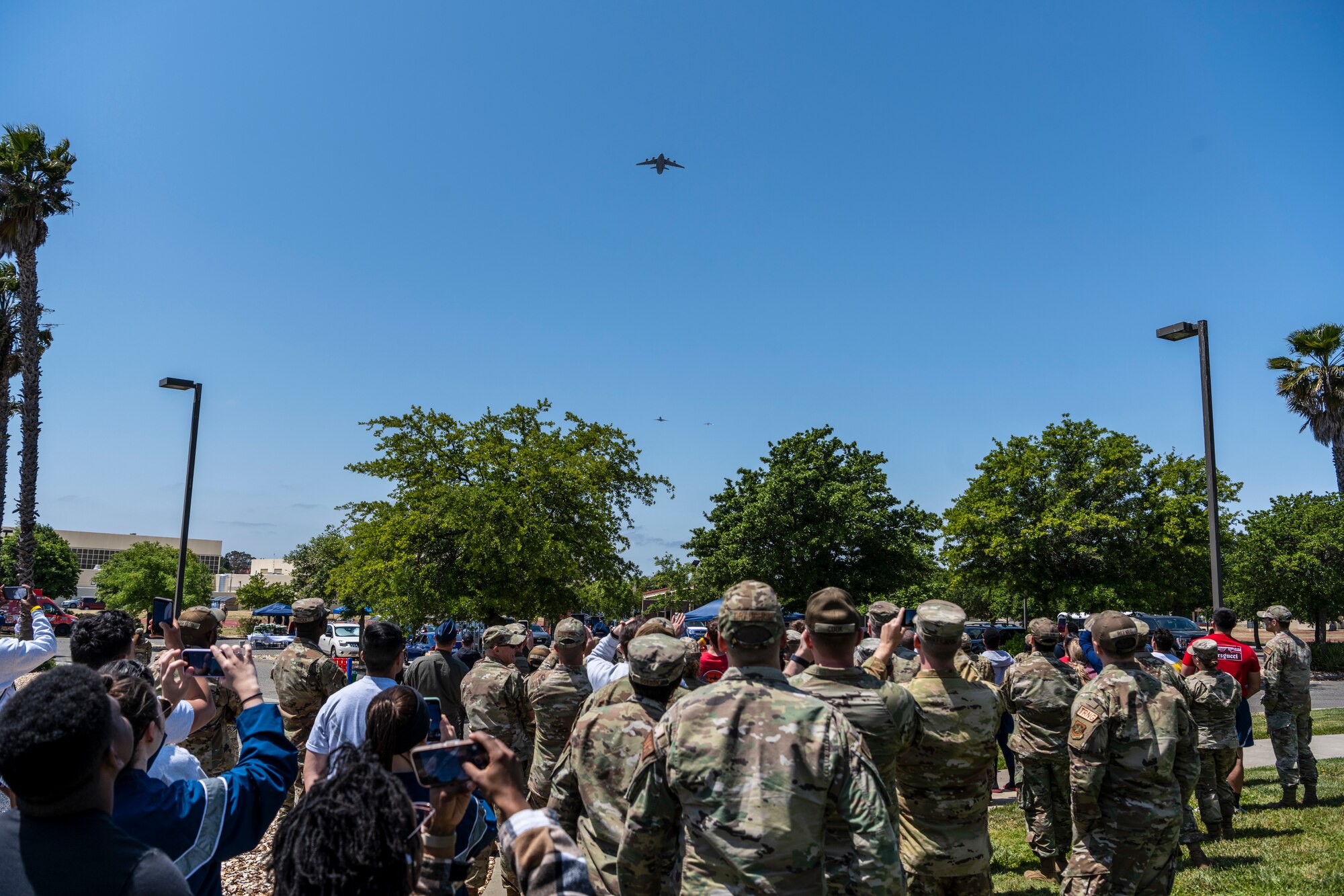 Airplanes fly in the sky over a crowd of people