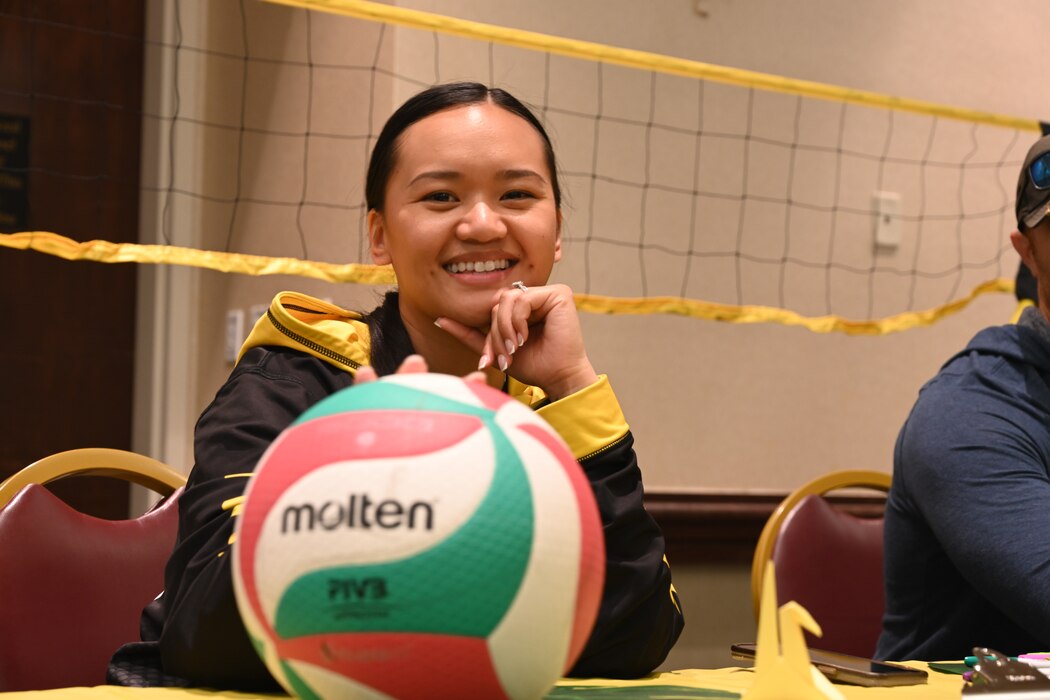 woman poses with volleyball