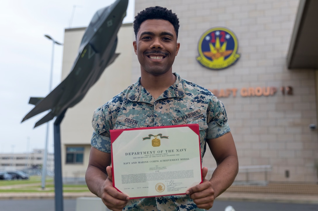 U.S. Marine Corps Sgt. Issiaah Green, a data systems administrator with Marine Aircraft Group 12, poses for a photo with his Navy and Marine Corps Achievement Medal award at Marine Corps Air Station Iwakuni, Japan, May 18, 2023. Green was awarded the Navy and Marine Corps Achievement Medal for establishing bilateral secured networks, broadening MAG-12 communication capabilities and enabling the use of streamlined logistics chain systems in deployed environments. (U.S. Marine Corps photo by Cpl. Tyler Harmon)