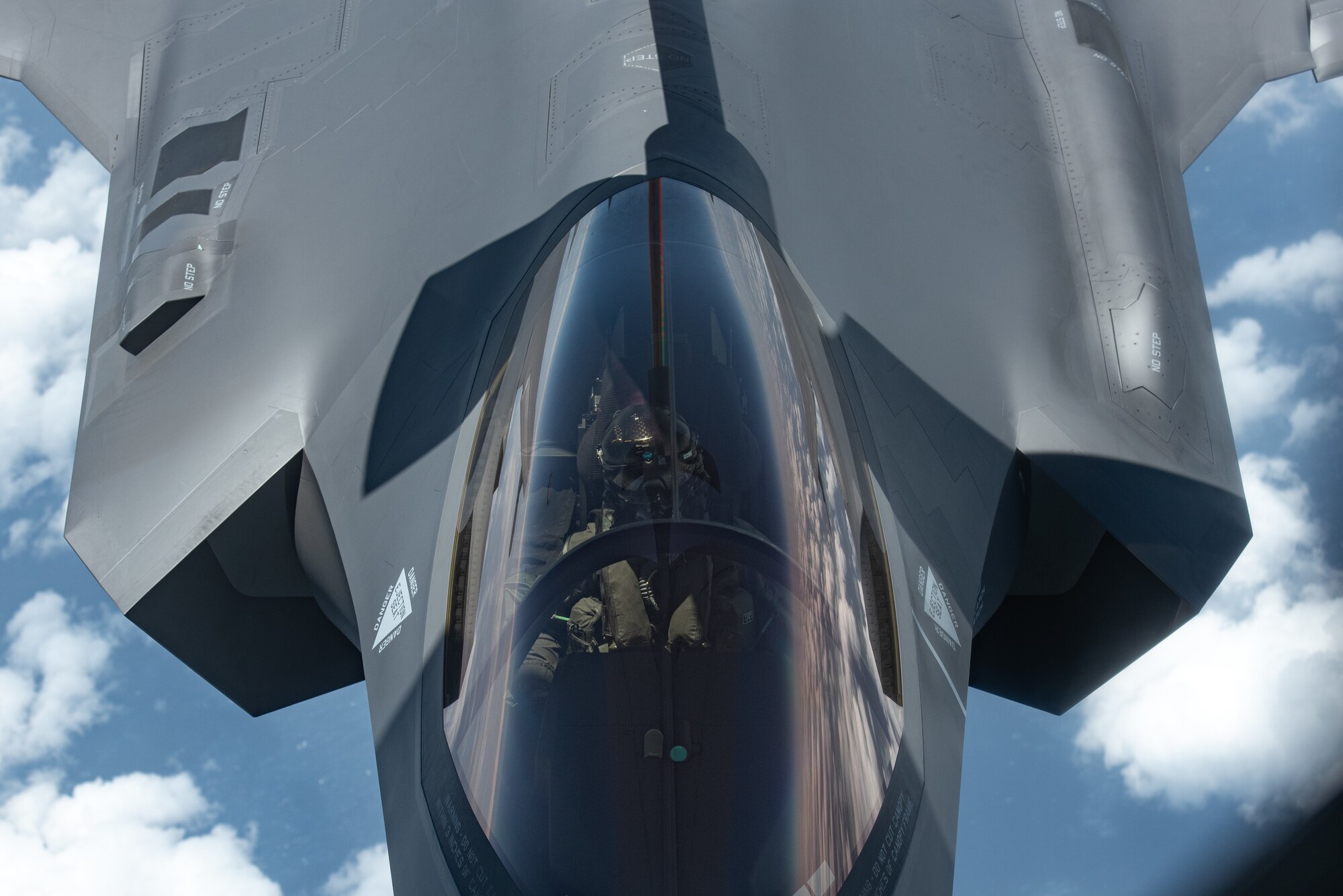 a pilot flies jet while receiving fuel in-flight