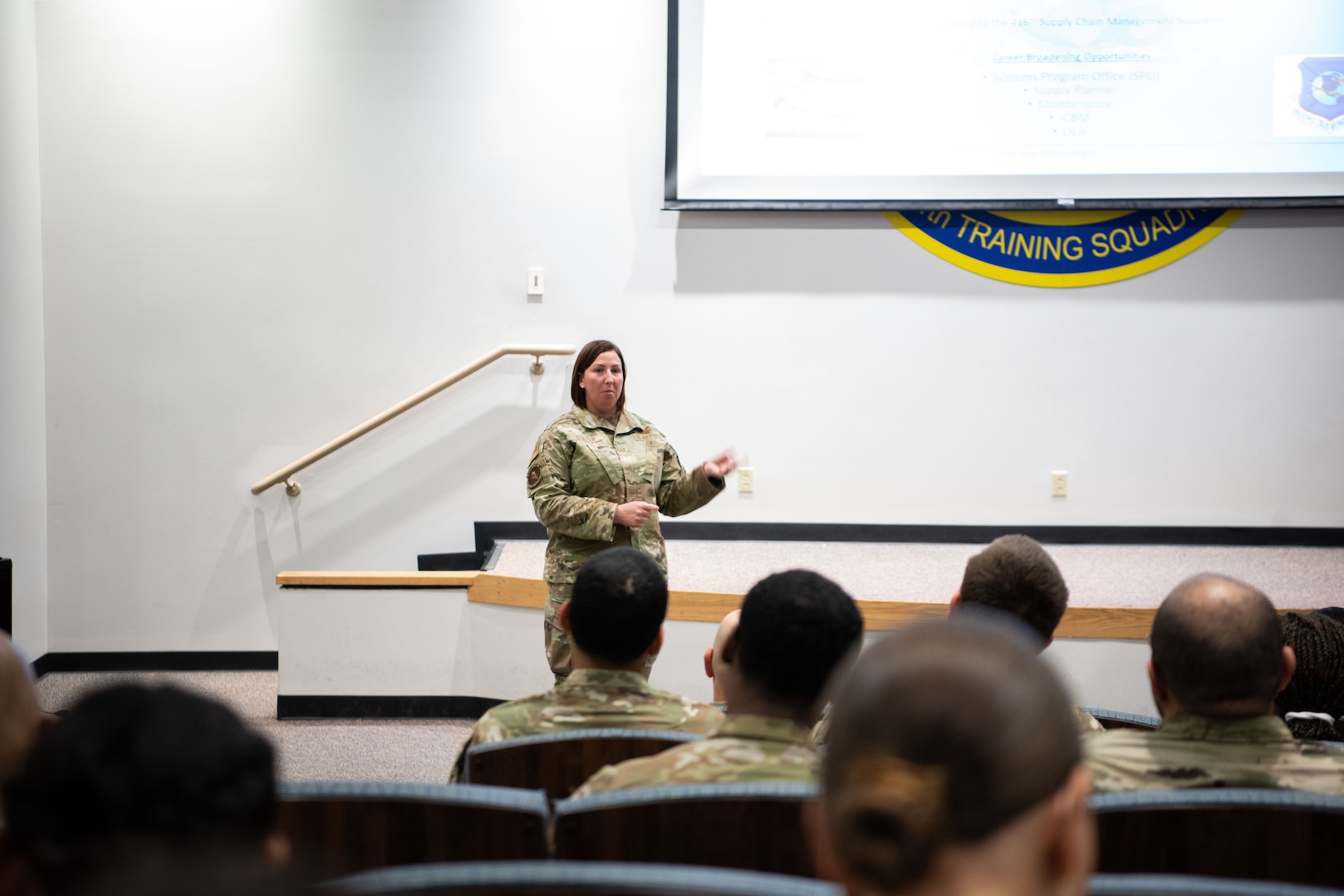 Master Sgt. Colleen Stalder, 416th Supply Chain Management Squadron, motions as she speaks to technical training students, 344th Training Squadron at JBSA-Lackland, May 9, 2023. Approximately 100 Airmen attended the briefing as career field managers discussed a variety of jobs in their specialty across the Air Force and helped them learn about future potential opportunities. (U.S. Air Force photo by Vanessa R. Adame)