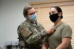 A military health specilist checks the heartbeat of a servicemember