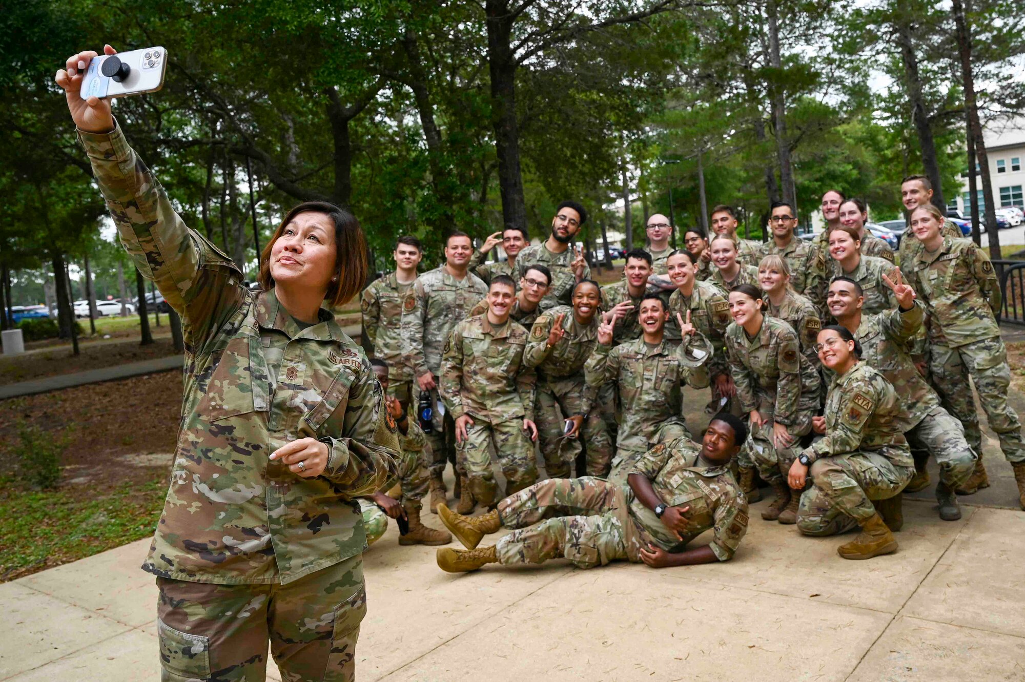 Chief Master Sgt. of the Air Force JoAnne S. Bass takes a selfie with Eglin Air Force Base personnel after a breakfast-with-Airmen meeting during a visit to Eglin AFB, Fla., May 23, 2023. The Enlisted Swap Assignment Program goes live June 1, 2023 for senior master sergeants and below with a current assignment. This new policy provides Airmen with more control and new flexibilities in their assignment process. (U.S. Air Force photo by Staff Sgt. Amber Litteral)