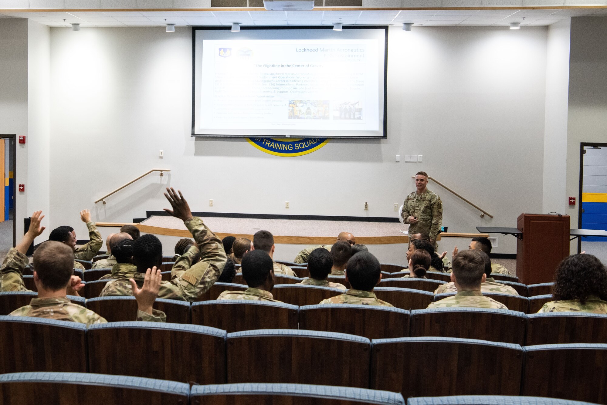 Airmen raise their hands during a briefing at the 344th Training Squadron at JBSA-Lackland, May 9, 2023. Approximately 100 Airmen attended the briefing as career field managers discussed a variety of jobs in their specialty across the Air Force and helped them learn about future potential opportunities. (U.S. Air Force photo by Vanessa R. Adame)