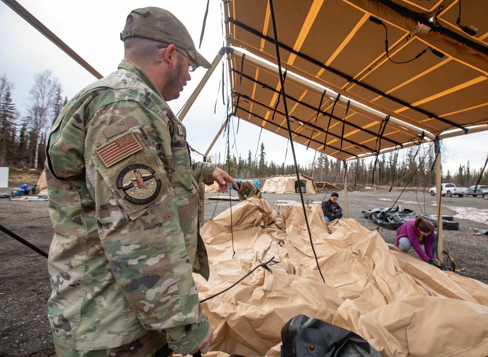 U.S. Air Force Tech. Sgt. Austin Myers, left, a water and fuel systems maintenance supervisor assigned to 773rd Civil Engineer Squadron, secures solar panels to a tent frame for an Agile Combat Employment air transportable clinic during Northern Edge 23-1, May 9, 2023, at Joint Base Elmendorf-Richardson, Alaska.