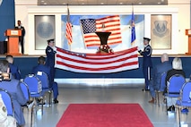 Two men in military uniform folding a United States flag