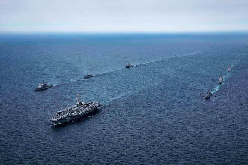 Ships move in formation at sea.