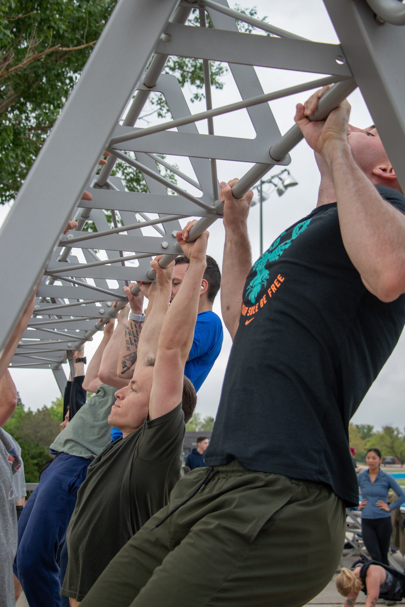 Airmen and Guardians from Delta 3 complete pull-ups as one of four grueling exercises during the Memorial Day workout "Murph."