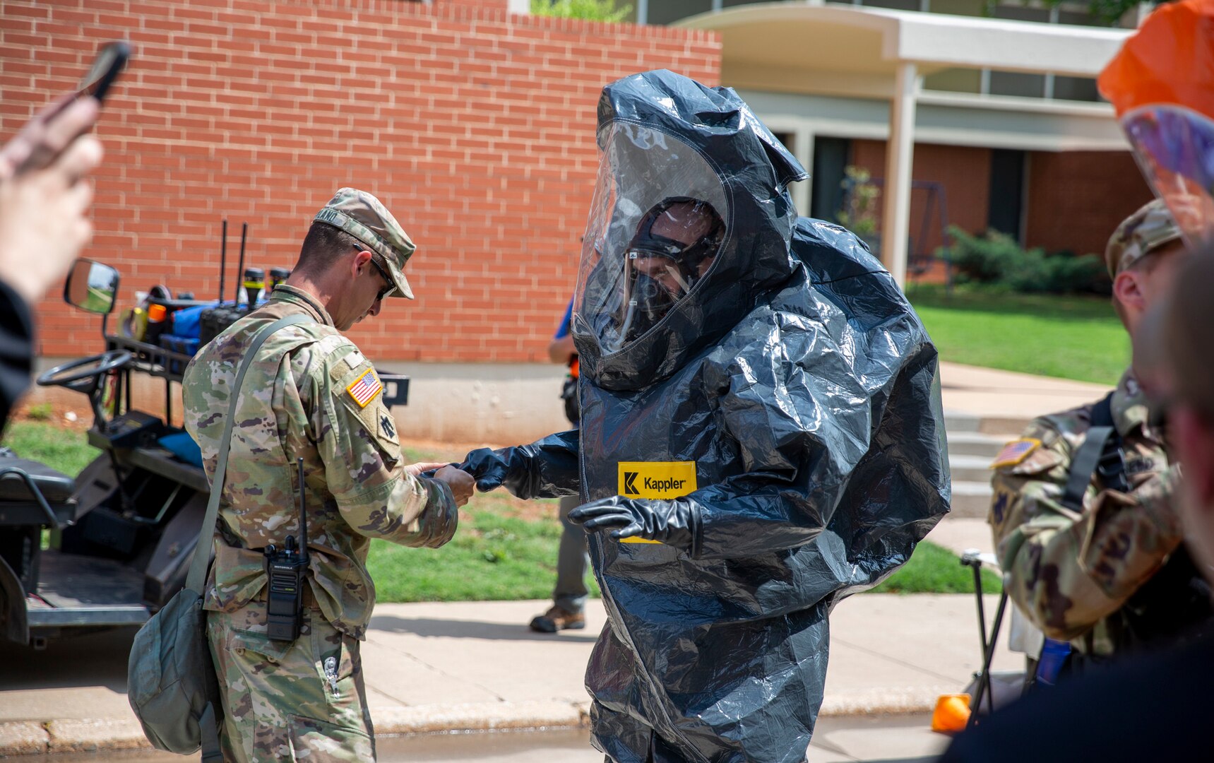 Oklahoma National Guard members with the 63rd Civil Support Team Sgt. 1st Class Ronald Poland (left) helps Sgt. Douglas Engel (right) don his protective gear during a training exercise in Weatherford, Oklahoma, May 23, 2023. In a joint effort to enhance emergency response capabilities, the Oklahoma National Guard's 63rd CST collaborated with local first responders during a full-scale exercise held in Custer and Washita County and the City of Weatherford, May 23-25, 2023. The comprehensive exercise provided an invaluable opportunity for all participants to enhance their coordination, communication, and response capabilities. (Oklahoma National Guard photo by Leanna Maschino)