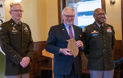 Maj. Gen. Rodney Boyd, Assistant Adjutant General – Army and Commander of the Illinois Army National Guard, and Col. Michael Eastridge, former commander of the 33rd Infantry Brigade Combat Team, present Patrick Van Nevel, Honorary Consul of the Kingdom of Belgium, with a plaque commemorating the shared history between the Illinois National Guard and Belgium.