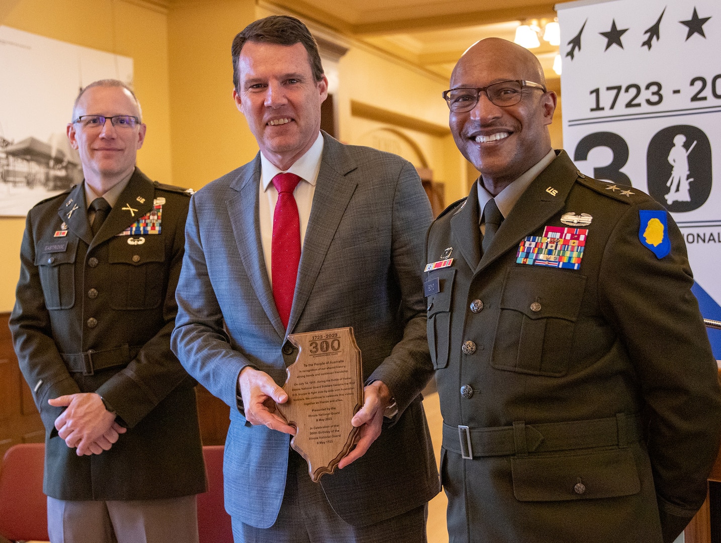 Maj. Gen. Rodney Boyd, Assistant Adjutant General – Army and Commander of the Illinois Army National Guard, and Col. Michael Eastridge, former commander of the 33rd Infantry Brigade Combat Team, present Chris Elstoft, Consul General of Australia in Chicago, with a plaque honoring the shared history between the Illinois National Guard and Australia.