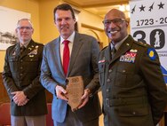 Maj. Gen. Rodney Boyd, Assistant Adjutant General – Army and Commander of the Illinois Army National Guard, and Col. Michael Eastridge, former commander of the 33rd Infantry Brigade Combat Team, present Chris Elstoft, Consul General of Australia in Chicago, with a plaque honoring the shared history between the Illinois National Guard and Australia.