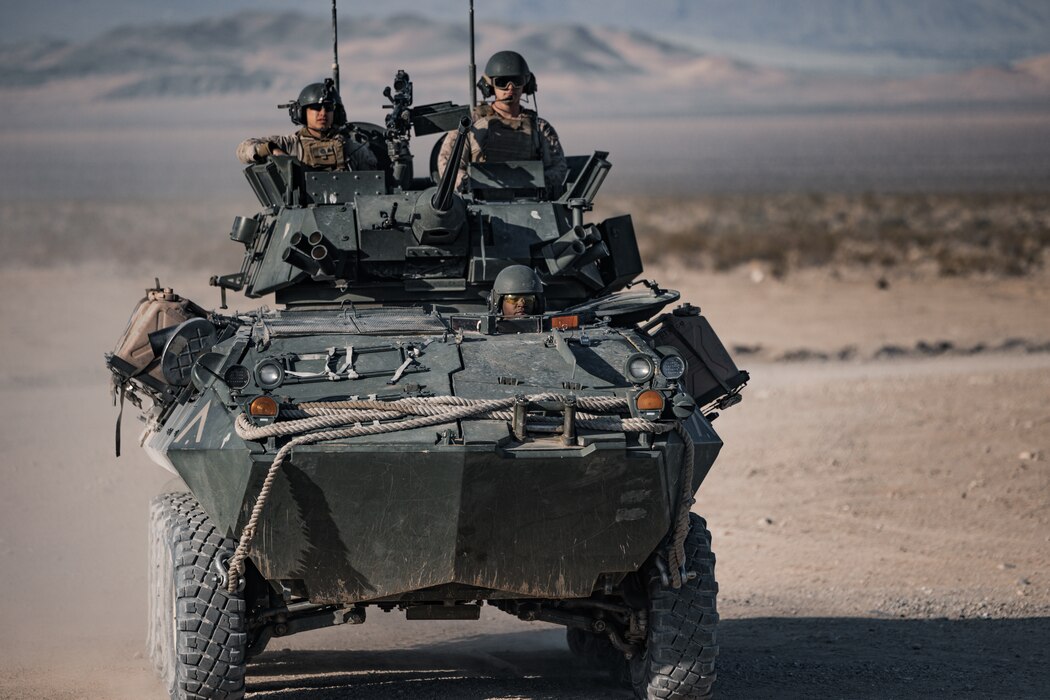 two U.S. Marines navigate a light armored vehicle in the California desert