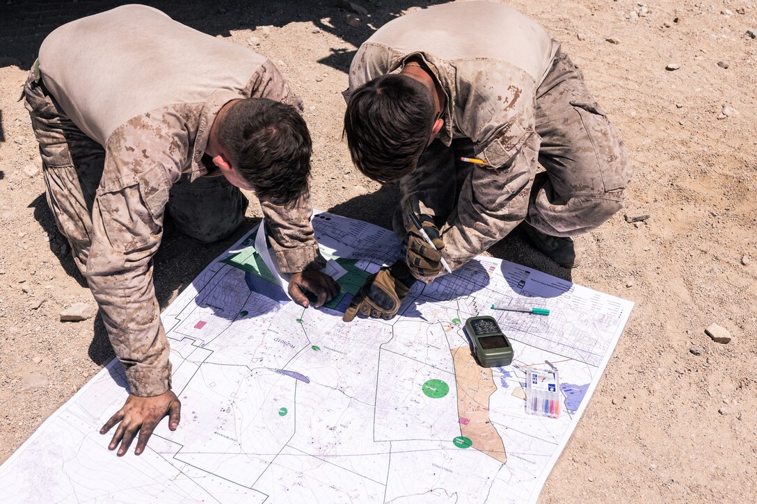 U.S. Marines plot grid points on a map prior to departing for the land navigation portion of the 2023 Bushmaster Challenge at Marine Corps Air-Ground Combat Center, Twentynine Palms, California, May 9, 2023. The purpose of the competition was to evaluate the Marines’ tactical and technical expertise and identify the best Light Armored Vehicle 25 crew from 1st, 2nd, and 4th Marine Division. (U.S. Marine Corps photo by Cpl. Andrew Bray)