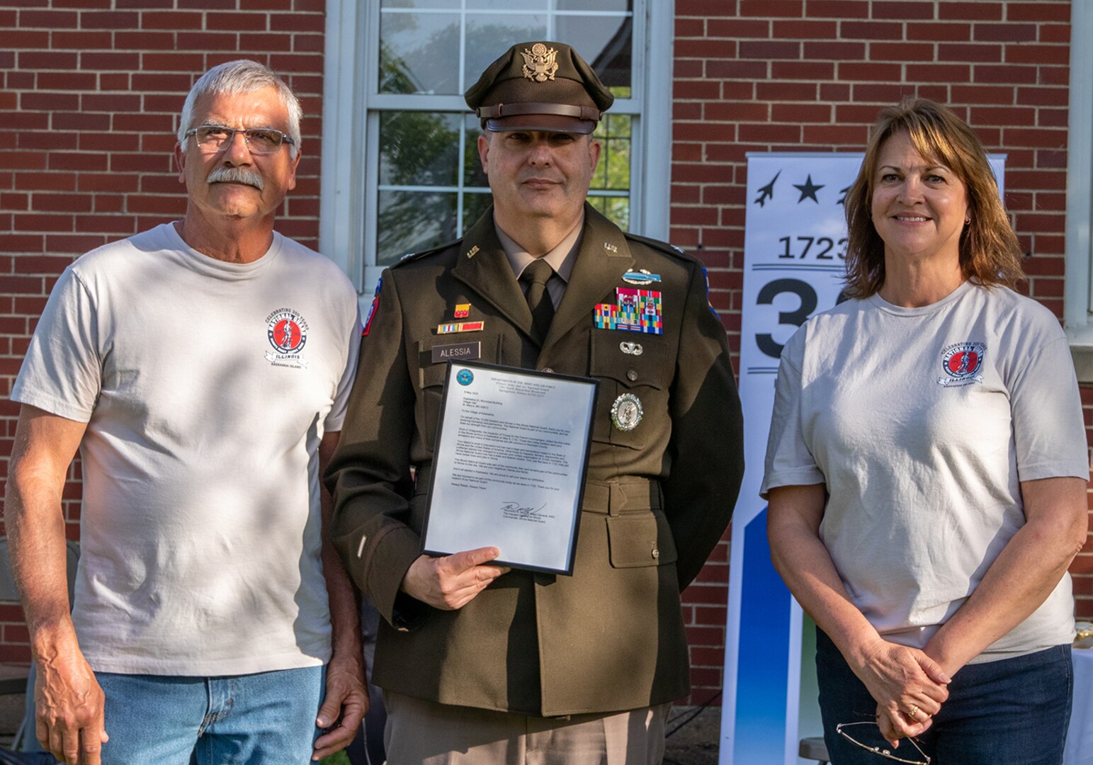 Brig. Gen. Mark Alessia, Director of the Illinois National Guard Joint Staff, presents a letter of Recognition to the Village of Kaskaskia from Maj. Gen. Rich Neely, the Adjutant General of Illinois and Commander of the Illinois National Guard, to Michael Sulser, President of the Village of Kaskaskia, and his wife, Mary, during the Illinois National Guard’s 300th birthday celebration in Kaskaskia May 9.