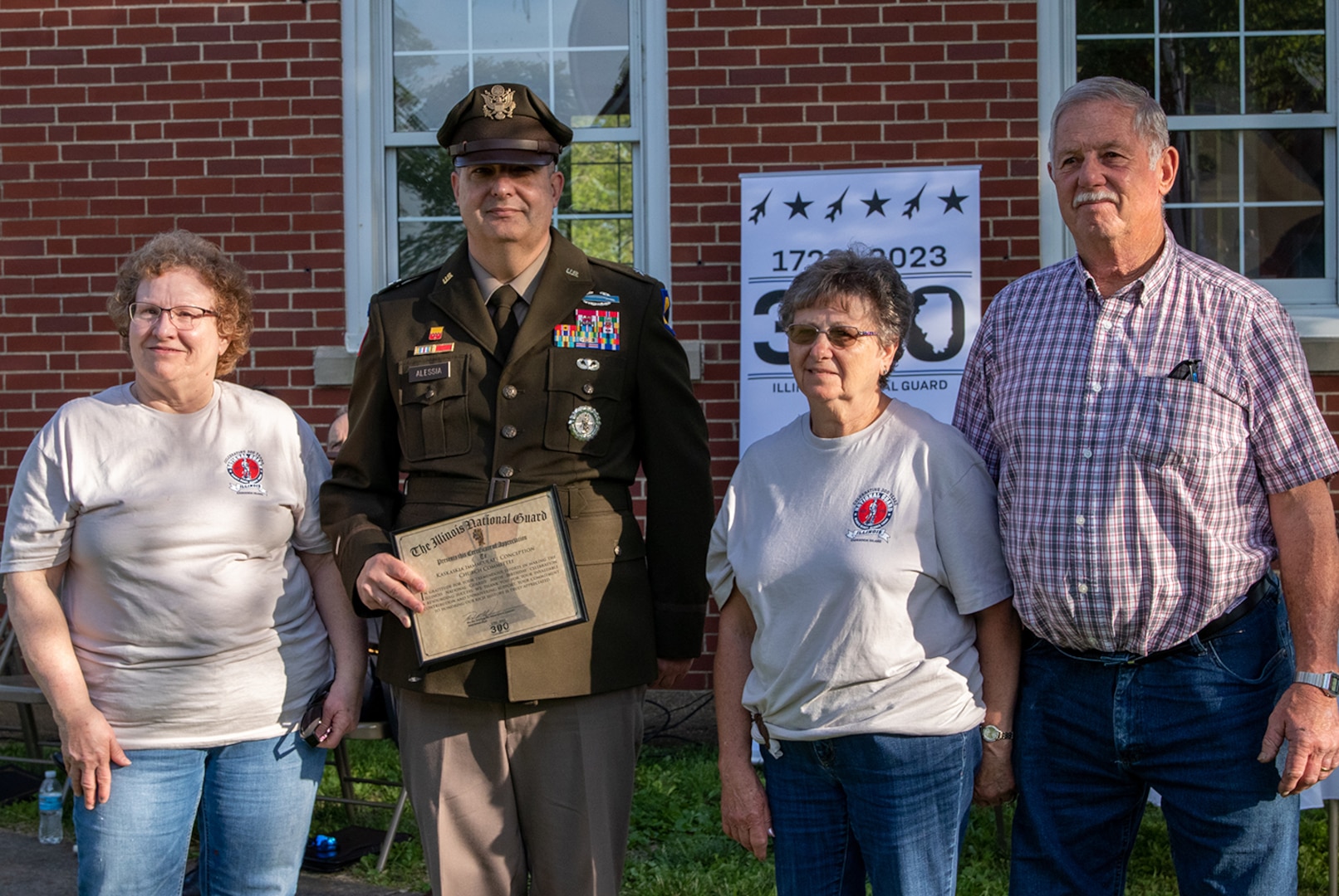 Brig. Gen. Mark Alessia, Director of the Illinois National Guard Joint Staff, presents a certificate of appreciation from Maj. Gen. Rich Neely, the Adjutant General of Illinois and Commander of the Illinois National Guard, to the Immaculate Conception Church committee, during the Illinois National Guard’s 300th birthday celebration in Kaskaskia May 9.