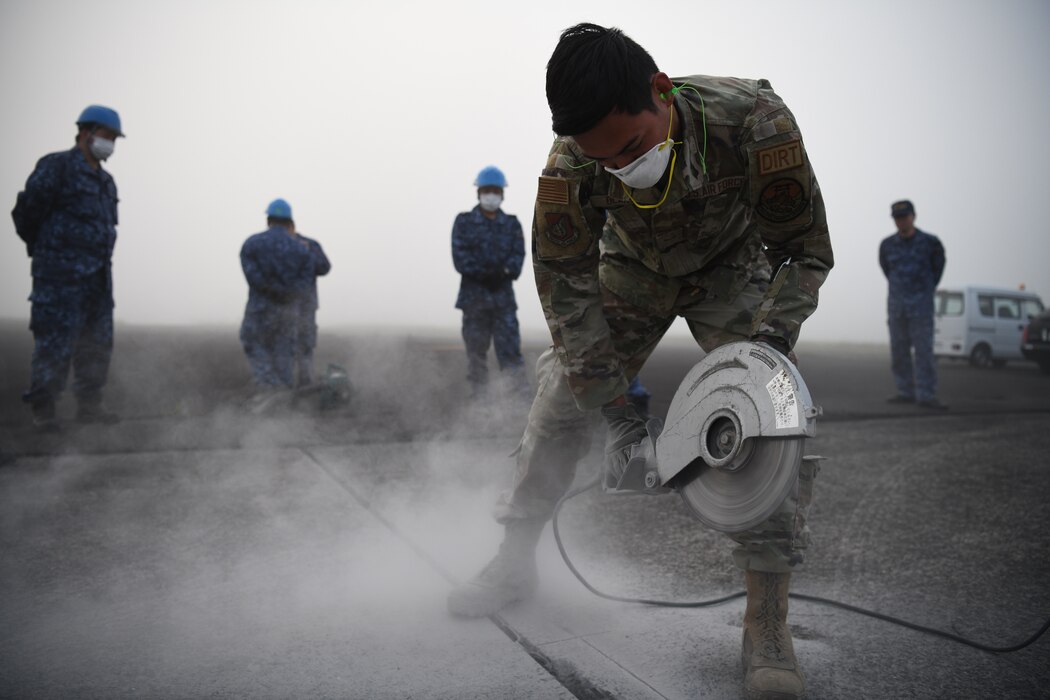 Airman 1st Class John Olarte, 374th Civil Engineer Squadron pavement and heavy equipment journeyman, cuts concrete