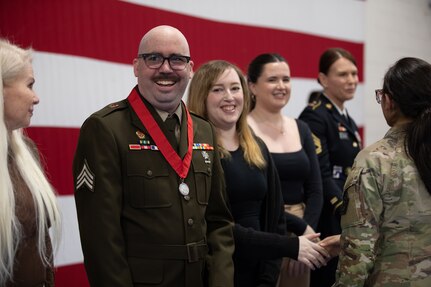 Newly-promoted Sgt. Maxwell Ehrlich, assigned to Charlie Battery, 2-218th Field Artillery Battalion based in Portland Oregon, stands with his family and friends at the conclusion of the promotion ceremony May 6, 2023 at North Riverside Armory, Chicago Illinois.