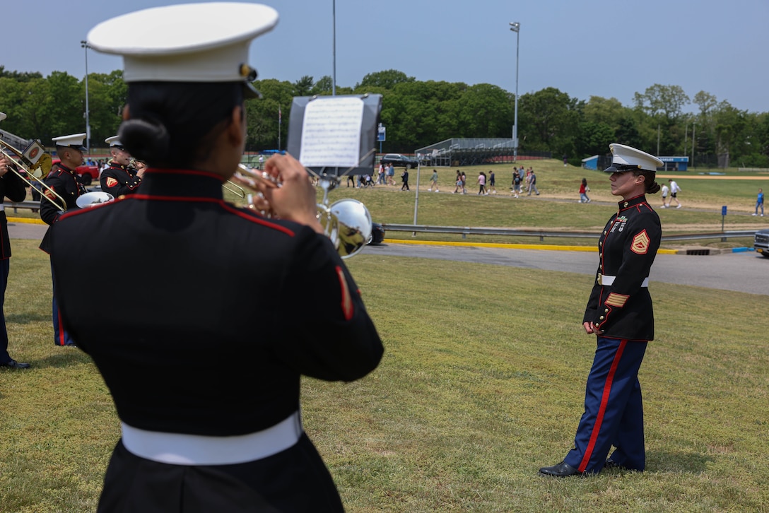 U.S. Marine Corps Gunnery Sgt. Anna H. Henrickson, band director, warms up The Quantico Marine Band at Hauppauge High School, Long Island, New York during the first day of Fleet Week New York (FWNY), May 24, 2023. More than 3,000 service members from the Marine Corps, Navy and Coast Guard and our NATO allies from Great Britain, Italy and Canada are engaging in special events throughout New York City and the surrounding Tri-State Region during FWNY 2023, showcasing the latest capabilities of today’s maritime services and connecting with citizens. The events include free public ship tours, military static displays, and live band performances and parades. (U.S. Marine Corps photo by Lance Cpl. David Brandes)