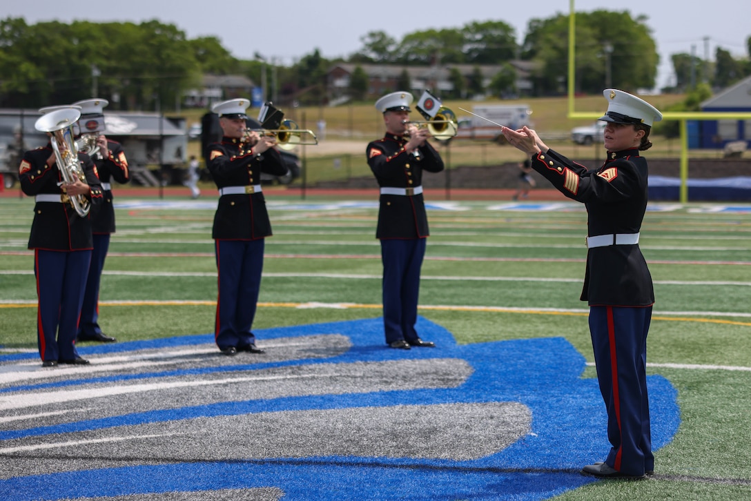 U.S. Marine Corps Gunnery Sgt. Anna H. Henrickson, band director, conducts The Quantico Marine Band at Hauppauge High School, Long Island, New York during the first day of Fleet Week New York (FWNY), May 24, 2023. More than 3,000 service members from the Marine Corps, Navy and Coast Guard and our NATO allies from Great Britain, Italy and Canada are engaging in special events throughout New York City and the surrounding Tri-State Region during FWNY 2023, showcasing the latest capabilities of today’s maritime services and connecting with citizens. The events include free public ship tours, military static displays, and live band performances and parades. (U.S. Marine Corps photo by Lance Cpl. David Brandes)