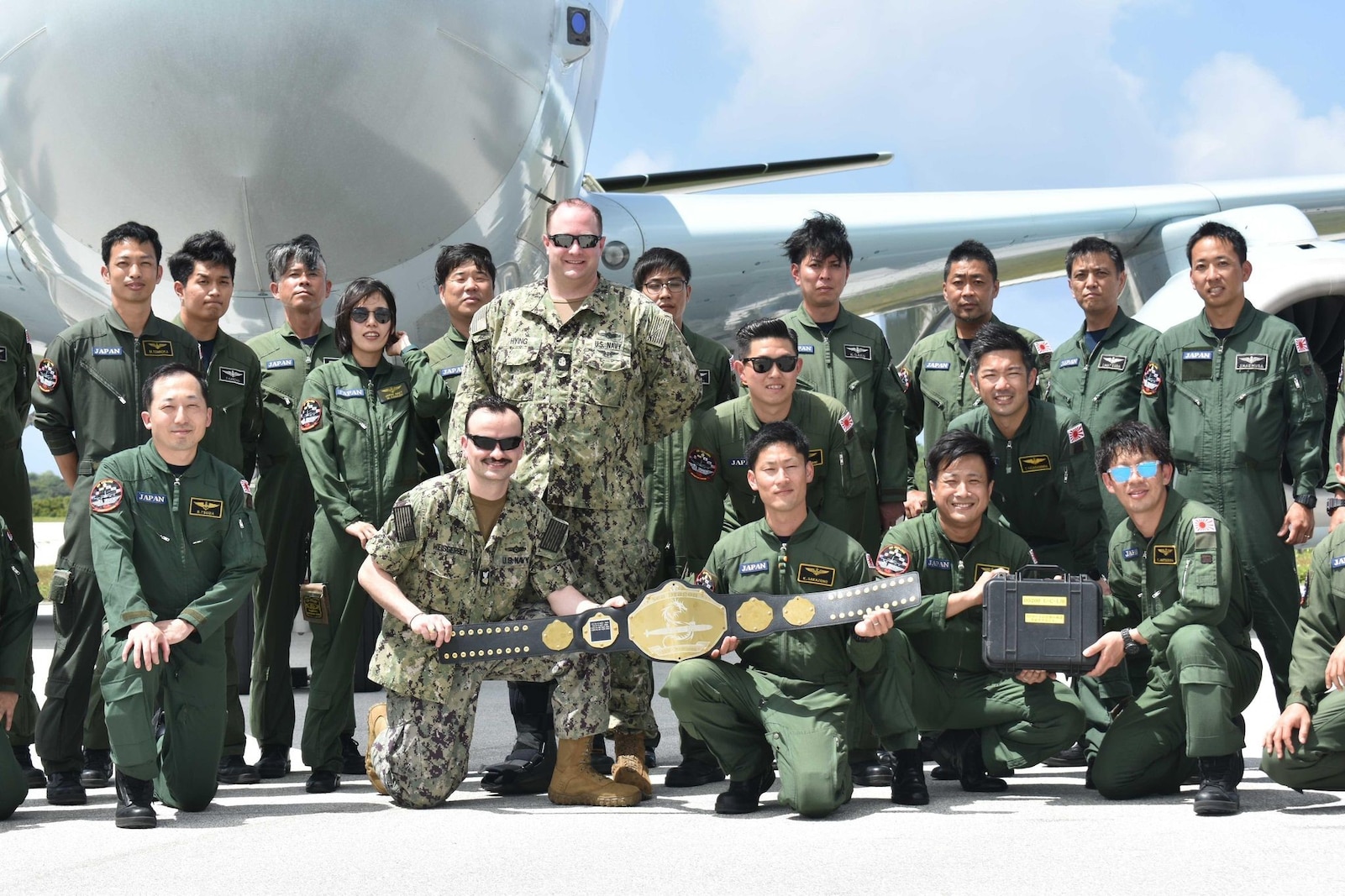 Winners of the highly competitive anti-submarine warfare (ASW) competition, aircrew and maintenance personnel from the Japan Maritime Self-Defense Force (JMSDF) pose with the Sea Dragon Championship Belt with Chief Aerographer’s Mate Kirk Hying and Aerographer’s Mate 1st Class Andrew Weisgerber in front of a JMSDF Kawasaki P-1.