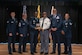 From left, U.S. Air Force Staff Sgt. Zachary Bozell, 316th Security Forces Squadron military working dog trainer, Chief Master Sgt. Jackson A. Helzer, 316th Wing command chief, Col. Todd E. Randolph, 316th Wing and installation commander at Joint Base Andrews, Md., Malik Aziz, Prince George's County chief of police, Col. Michael Morales, 316th Security Forces Group commander, and Tech. Sgt. Amaya, Tech. Sgt. Manuel Amaya, 316th Security Support Squadron combat arms noncommissioned officer in charge, participate in a ceremony at Prince George's County Police Department Headquarters in Upper Marlboro, Md., May 25, 2023. PGPD presented a gift of appreciation as a thank you to military members stationed at JB Andrews and in celebration of Military Appreciation Month. (U.S. Air Force photo by Senior Airman Daekwon Stith)