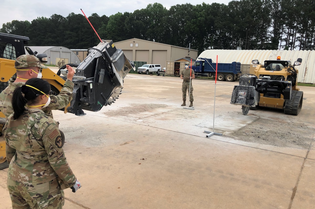 Airman guides a concrete cutting machine