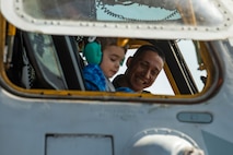 U.S. Marine Corps 1st Lt. Josh Camaligan, a CH-53E Super Stallion pilot, Marine Heavy Helicopter Training Squadron 302, smiles as he shows a child the inside of a CH-53E static display during the 2023 Westfield International Air Show at Barnes Air National Guard Base, Massachusetts, May 14, 2023. The two-day event allowed the 104th Fighter Wing and joint-service partners to strengthen their community ties with over 70,000 members of the public by showcasing their capabilities, aircraft and equipment. (U.S. Air National Guard photo by Staff Sgt. Hanna Smith)