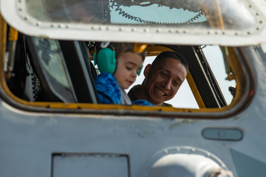 U.S. Marine Corps 1st Lt. Josh Camaligan, a CH-53E Super Stallion pilot, Marine Heavy Helicopter Training Squadron 302, smiles as he shows a child the inside of a CH-53E static display during the 2023 Westfield International Air Show at Barnes Air National Guard Base, Massachusetts, May 14, 2023. The two-day event allowed the 104th Fighter Wing and joint-service partners to strengthen their community ties with over 70,000 members of the public by showcasing their capabilities, aircraft and equipment. (U.S. Air National Guard photo by Staff Sgt. Hanna Smith)