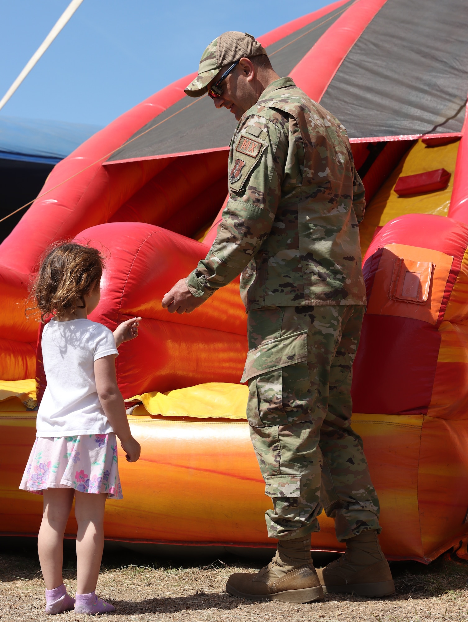 A U.S. Air Force member from the 104th Fighter Wing spends time with his daughter during the 2023 Westfield International Air Show, May 12, 2023, at Barnes Air National Guard Base, Massachusetts. Air shows are a public event held on base to provide an opportunity for people to see U.S. military air capabilities in action and meet the service members who fly and maintain the equipment. (Courtesy photo by Aedan Nault-Goodreau)