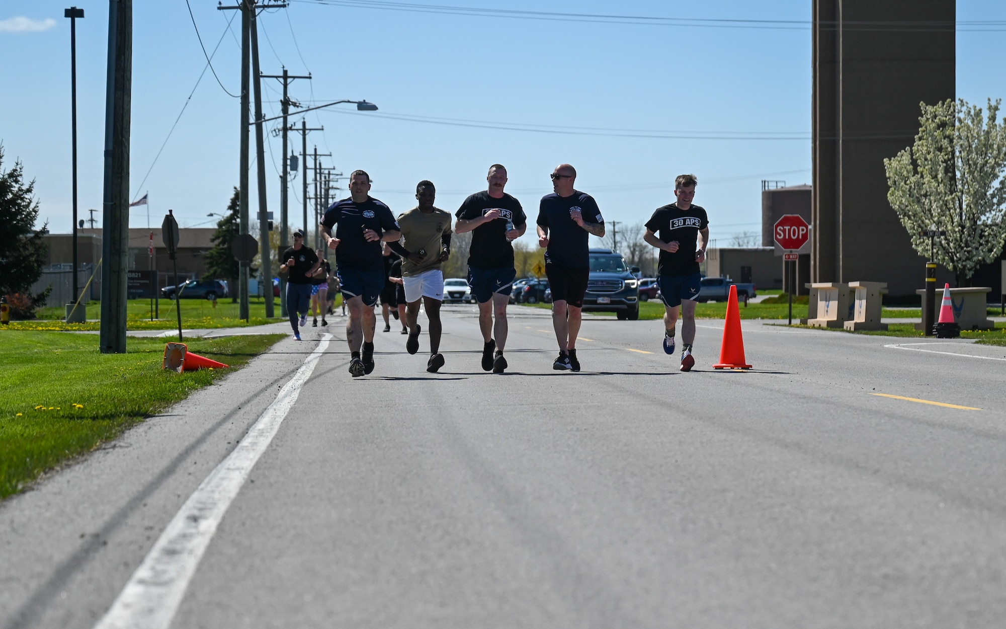 A line of port dawg memorial runner participants surpasses the halfway point of the 5k loop at Niagara Falls Air Reserve Station, New York on May 5, 2023.