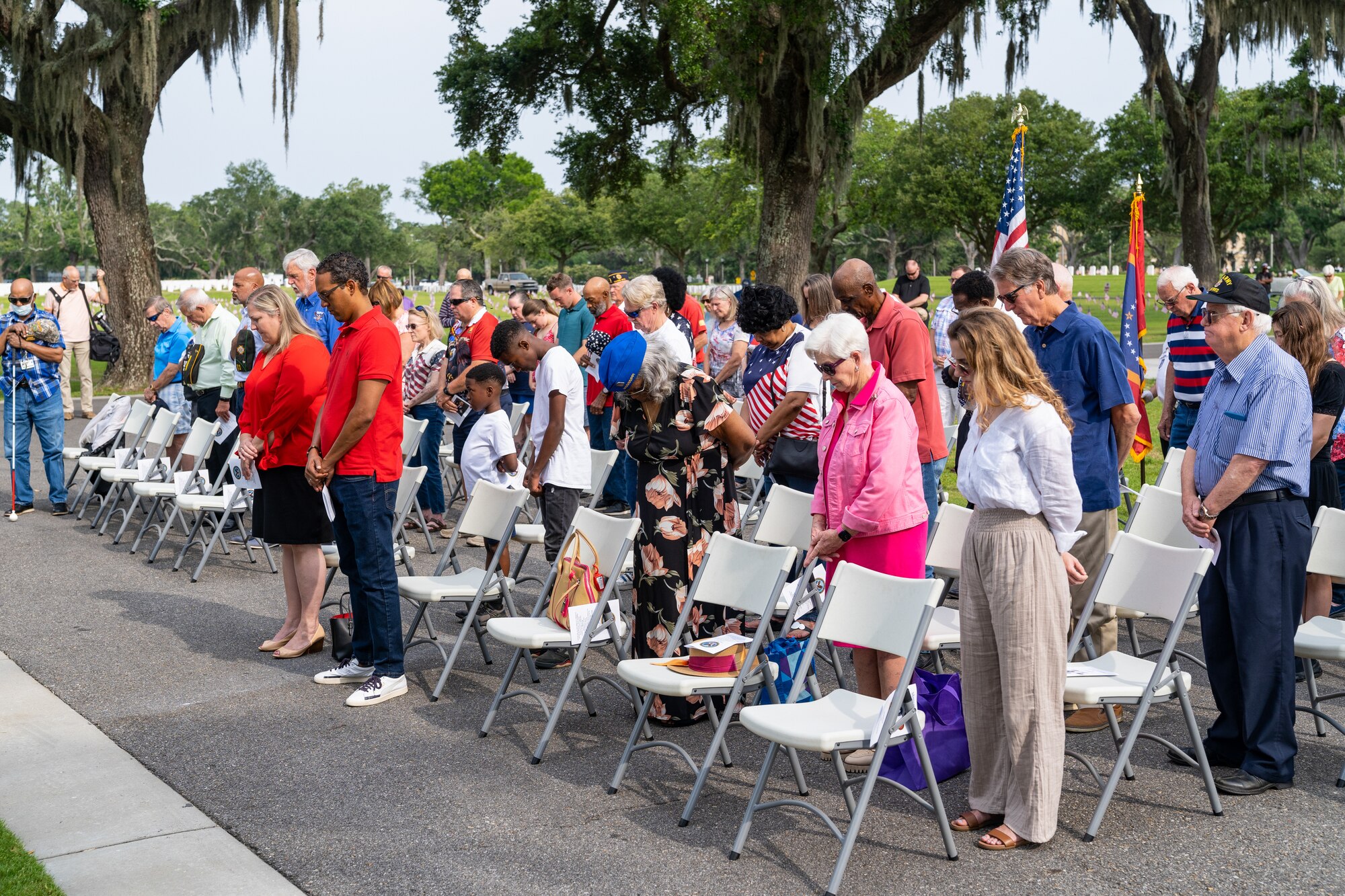 Guests bow their heads in prayer for the invocation during the Memorial Day ceremony at the Biloxi National Cemetery, Mississippi, May 29, 2023.