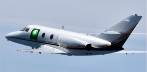 A test aircraft carries the sub-scale HARDROC beam director illuminated by a low-power scoring laser during an experimentation flight August 12, 2022. The HARDROC program evaluated in flight the ability of various aerodynamic flow control techniques to mitigate optical and mechanical distortions imparted on a laser beam leaving an airborne platform travelling at high speeds. (Courtesy photo)