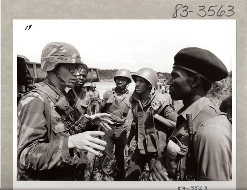 A soldier from the 82nd Airborne Division confers with Eastern Caribbean troops of the Multinational Security Force, Grenada, November 1983. (Source: U.S. Information Agency, NARA)