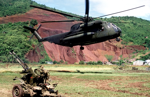 A U.S. Marine Corps Sikorsky CH-53D Sea Stallion helicopter hovers above the ground near a Soviet ZU-23 anti-aircraft weapon prior to picking it up during "Operation Urgent Fury", the U.S. invasion of Grenada in October 1983. (DoD photo)