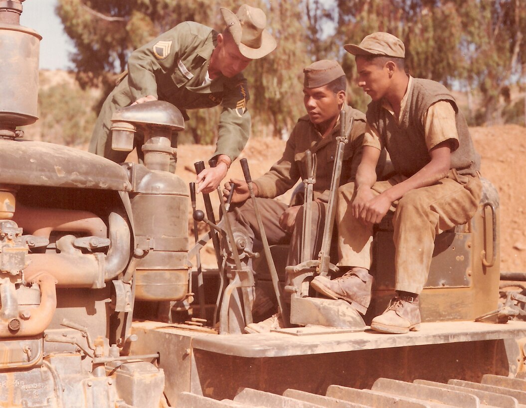 A U.S. military adviser instructs students on the use of engineering equipment, Bolivia, July 1963.