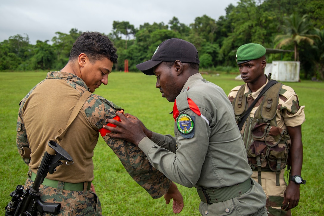 U.S. Marine Corps Private First Class Tashaun Eldridge, a Louisville, KY native and rifleman with Task Force 61/2.3 Fleet Anti-terrorism Security Team Europe, inspects the application of a tourniquet with a Gabonese Republican soldier, during Judicious Activation 2023 in Libreville, Gabon, Apr. 27, 2023. Task Force 61/2.3 provides capabilities such as rapid response expeditionary anti-terrorism and security operations in support of Commanders, United States European Command and as directed by Commander, U.S. 6th Fleet in order to protect vital naval and national assets.